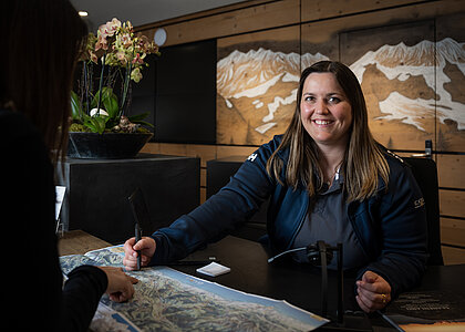 Dame die im Tourismusbüro Gstaad eine Beratung gibt.