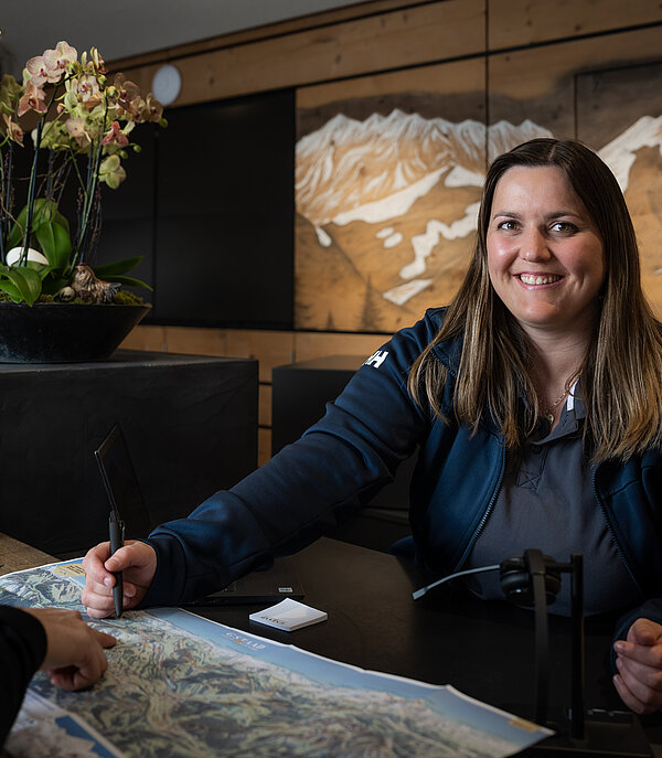 Lady giving advice at Gstaad tourist office.