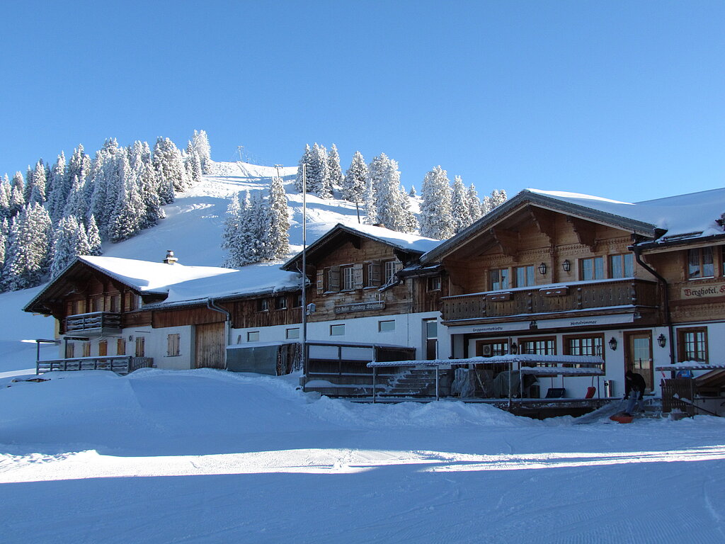 <p>Verschneites Berghotel inmitten einer herrlichen Schneelandschaft.</p>