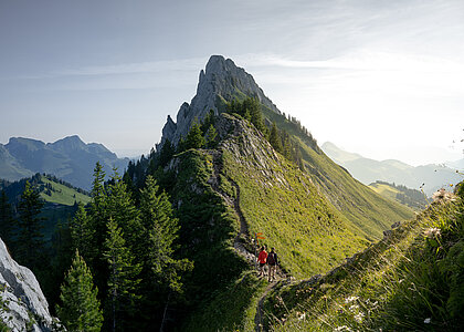 Breits frisch präparierte Skipiste mit imposanter Weitsicht und zwei Personen beim Skifahren