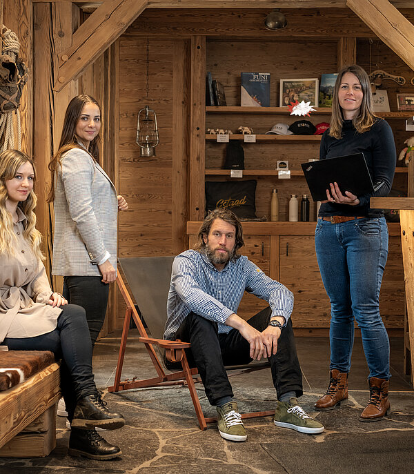 Dans un bureau d'accueil rustique, trois femmes et un homme attendent leurs hôtes avec impatience.