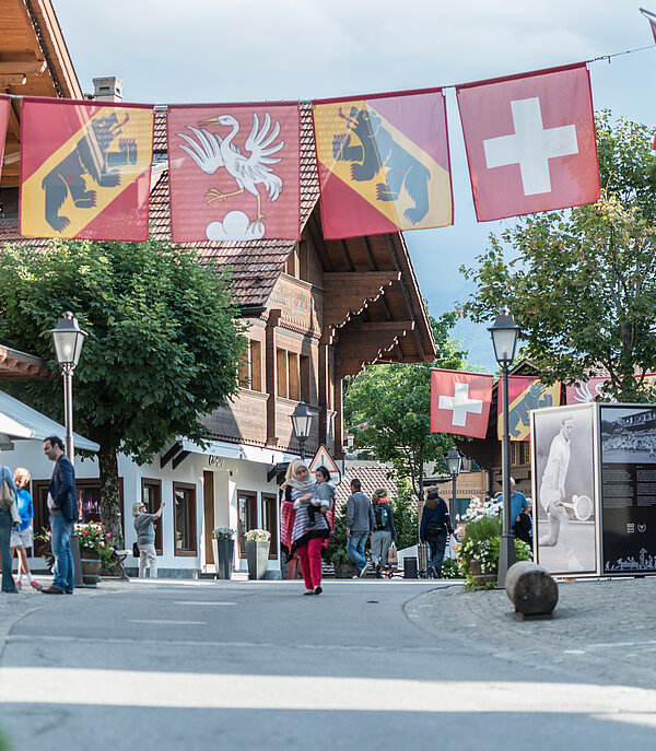 Flags of Switzerland, Bern and Saanen hanging over the promenade in Gstaad.