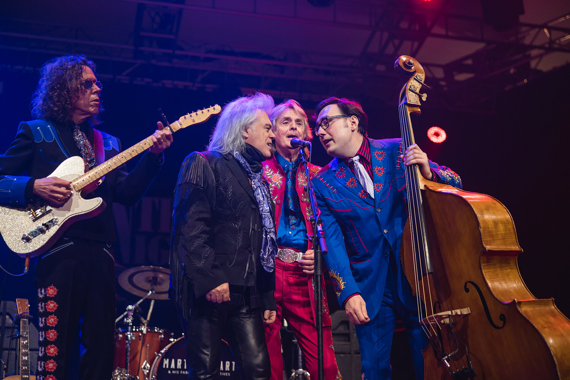 Vier Musiker einer Countryband singen und spielen auf der Bühne.