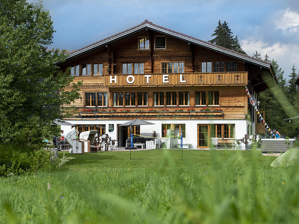 Kleines Hotel, im Vordergrund eine grüne Wiese.